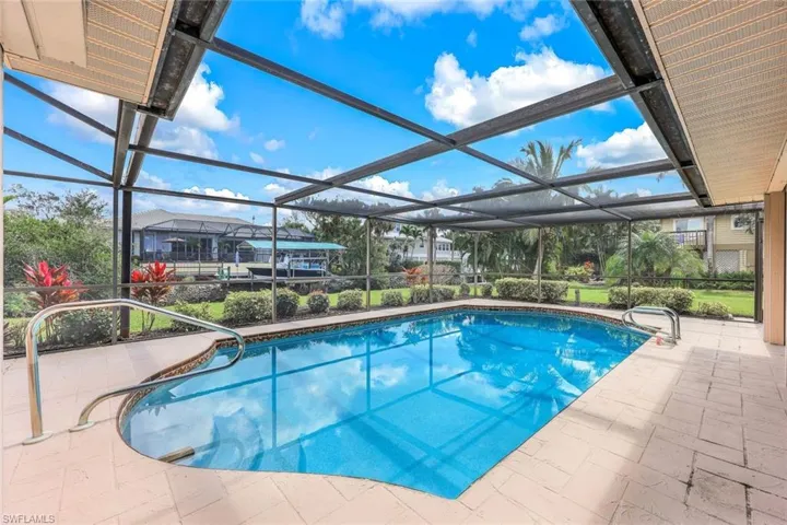 Gaze out over the sparkling pool and lush landscaping, where the tranquil canal provides the perfect backdrop for ultimate relaxation.