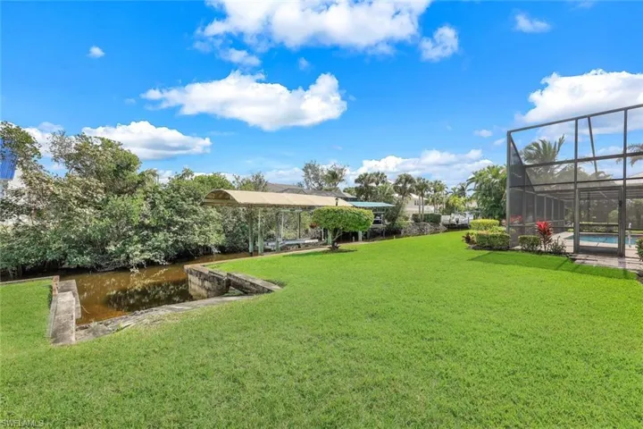 Picture yourself in this oversized backyard, where tropical landscaping, vibrant flowers, and serene waterfront views create the perfect escape.