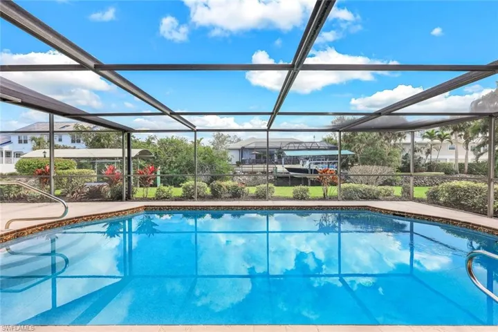 Step outside to your own private retreat, where the shimmering screened-in pool invites you to take a refreshing dip while enjoying breathtaking waterfront views.