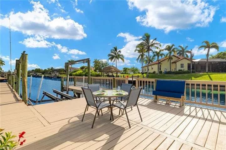 Wooden terrace featuring a boat dock and a water view