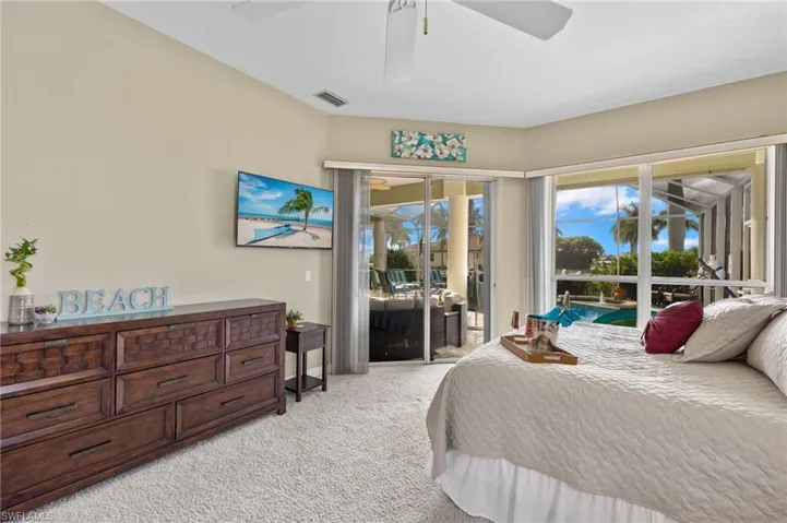 Carpeted bedroom featuring access to outside and ceiling fan