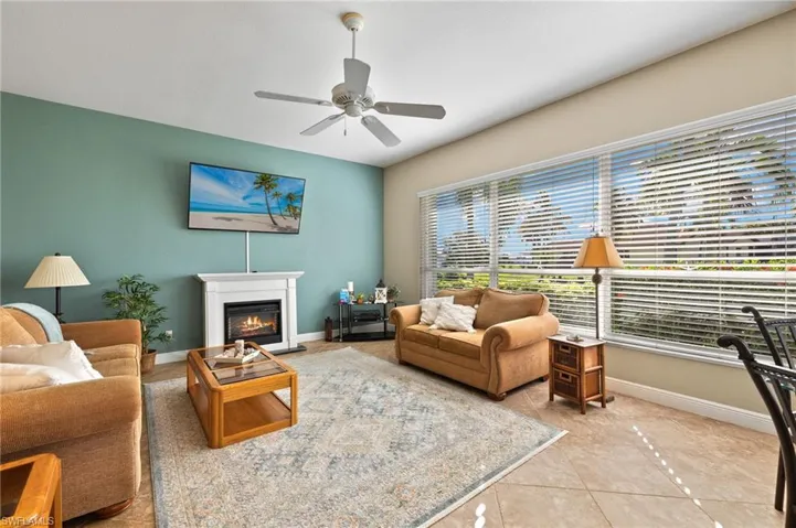 Living room with light tile patterned floors and ceiling fan