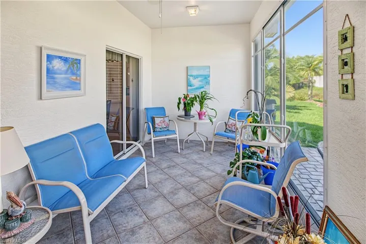 Screened-in porch featuring a tiled floor, white textured walls, and a sliding glass door