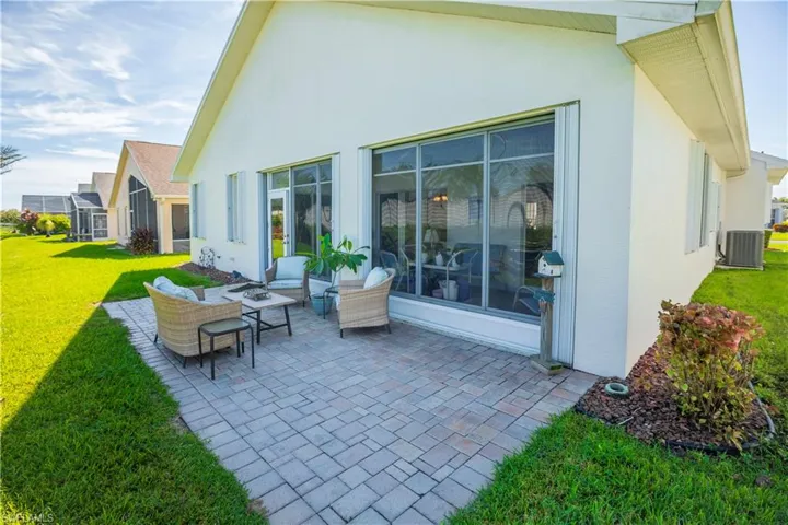 Exterior patio featuring paver stones, stucco siding, and a screened enclosure
