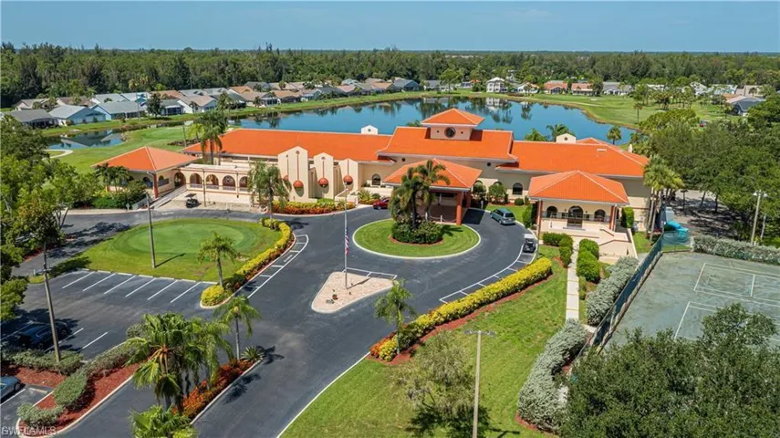 Spanish-style architecture featuring a tile roof, a circular drive, and an adjacent putting green