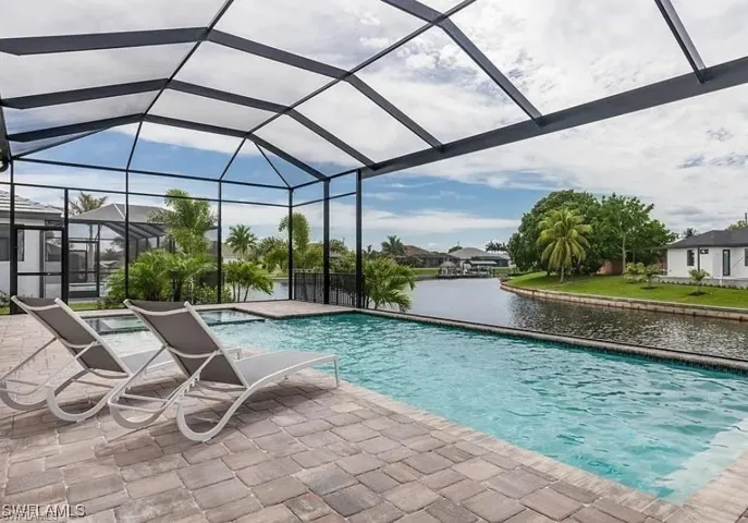 Outdoor pool featuring a water view, a lanai, a sunroom, and a patio area