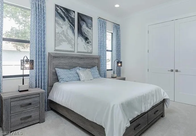 Bedroom with crown molding, light colored carpet, and recessed lighting