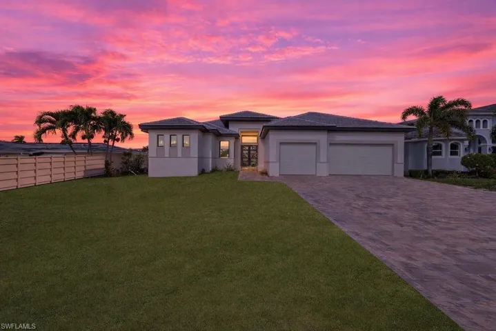 Prairie-style home with decorative driveway, an attached garage, and stucco siding