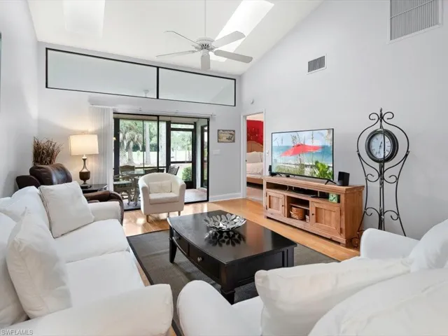 Living area with wood floors, vaulted ceiling, skylights (2017) and ceiling fan.