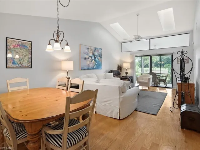 Living/Dining space featuring wood flooring, lofted ceiling and chandelier.