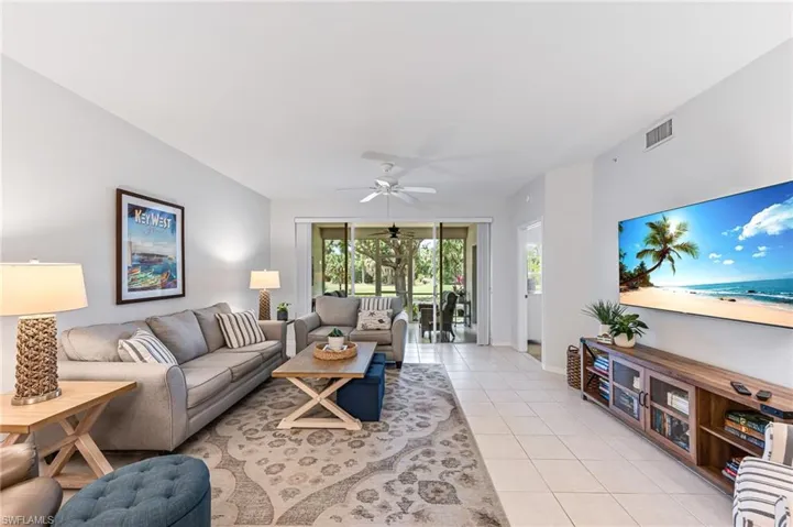 Living room featuring visible vents, a ceiling fan, baseboards, and light tile patterned flooring
