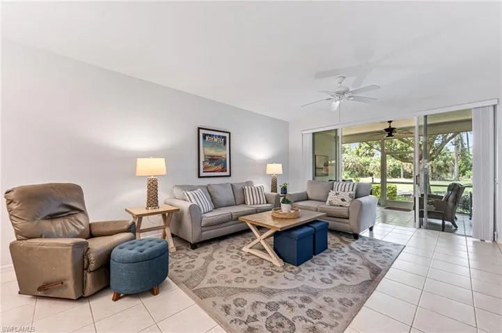 Living room with ceiling fan and light tile patterned floors