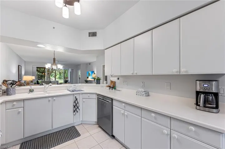 Kitchen featuring a sink, dishwasher, light countertops, light tile patterned floors, and visible vents