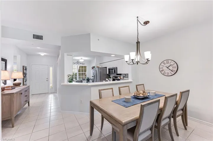 Dining room with baseboards, a notable chandelier, light tile patterned flooring, and visible vents