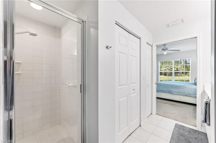 Ensuite bathroom with ceiling fan, visible vents, a shower stall, tile patterned floors, and ensuite bathroom