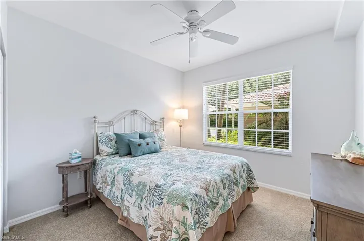 Bedroom with baseboards, carpet flooring, and a ceiling fan