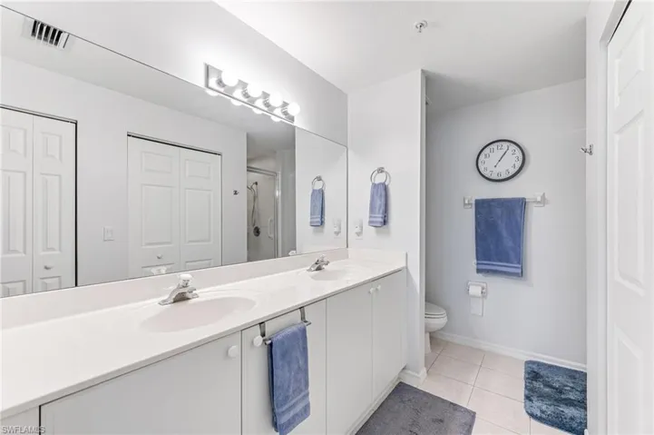 Full bathroom with toilet, visible vents, a sink, and tile patterned flooring