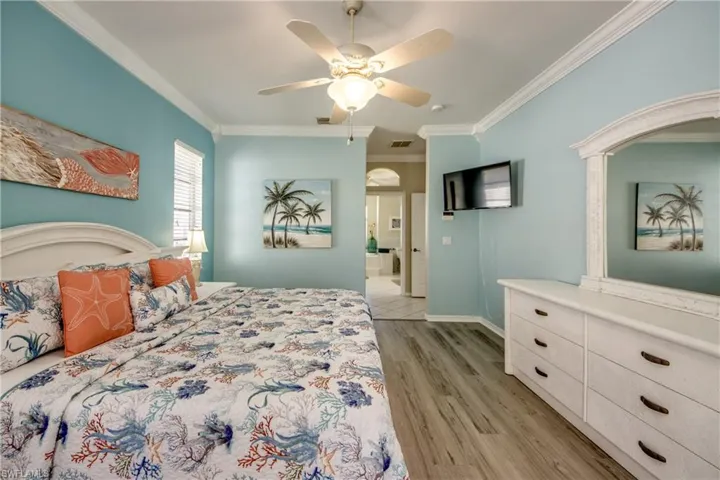 Tiled bedroom with ceiling fan and crown molding