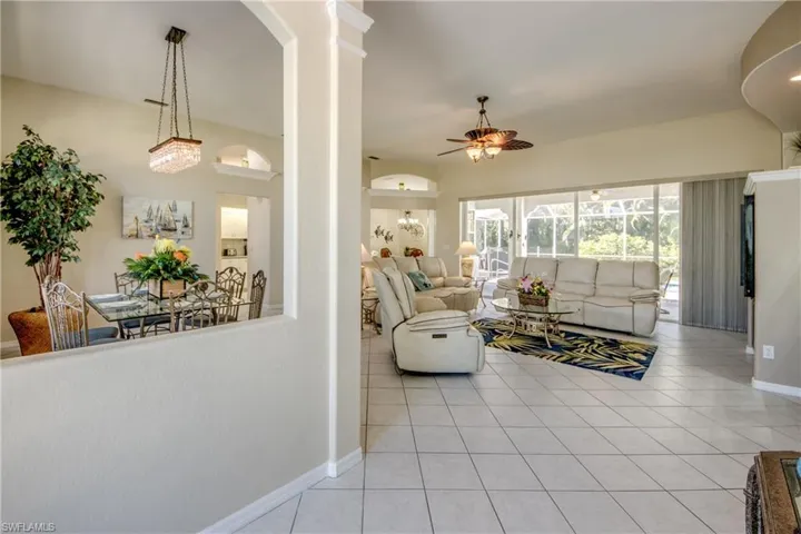 Living room with ceiling fan and light tile floors