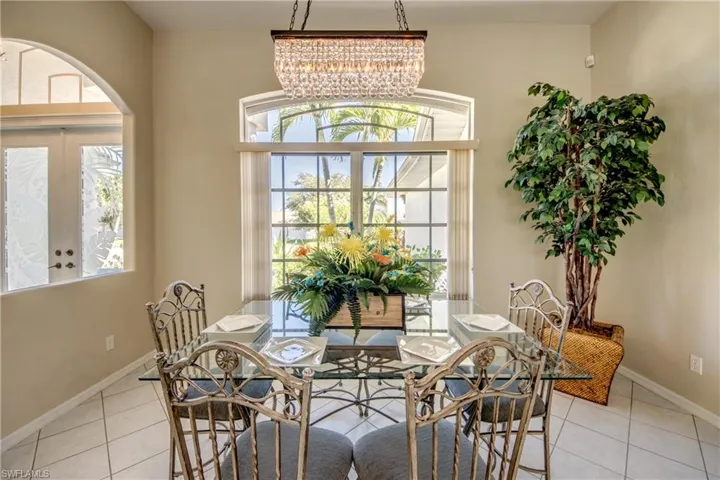 Tiled dining space with french doors and an inviting chandelier