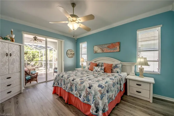 Bedroom featuring ceiling fan, multiple windows, hardwood / wood-style flooring, and access to exterior