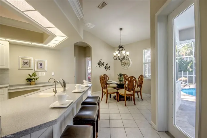 Tiled dining room featuring a chandelier and sink