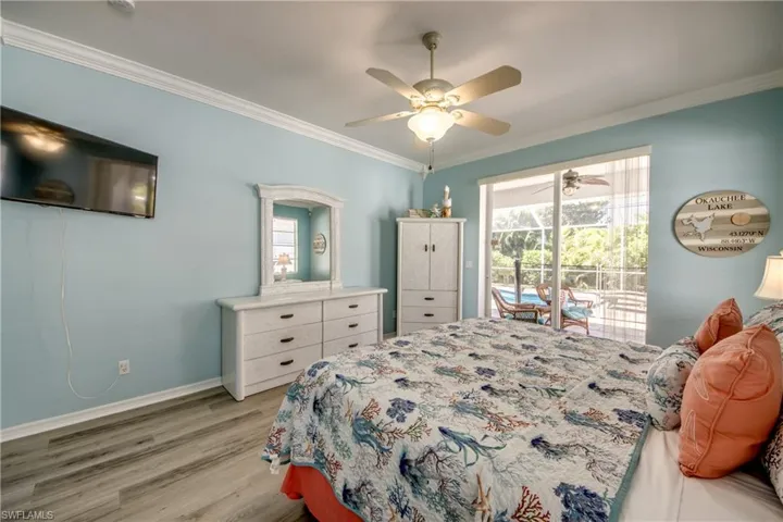 Bedroom featuring light wood-type flooring, ceiling fan, access to exterior, and crown molding