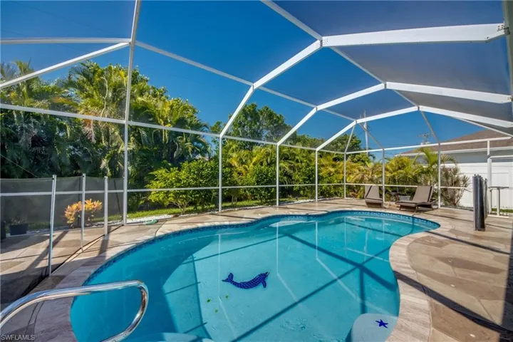 View of swimming pool featuring glass enclosure and a patio area