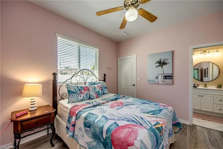 Bedroom featuring tile floors, ceiling fan, and ensuite bath