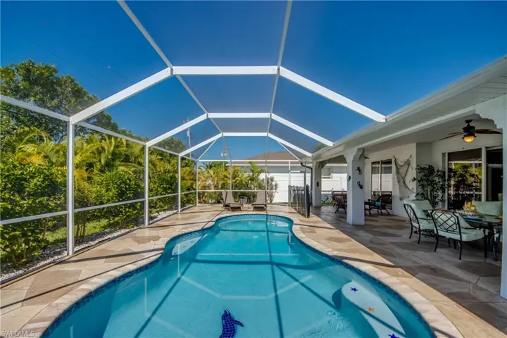 View of swimming pool with a patio, glass enclosure, and ceiling fan