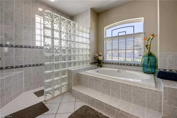 Bathroom featuring tile flooring and a relaxing tiled bath