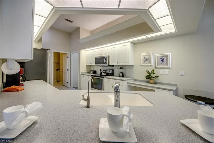 Kitchen featuring white cabinets, appliances with stainless steel finishes, sink, and tasteful backsplash