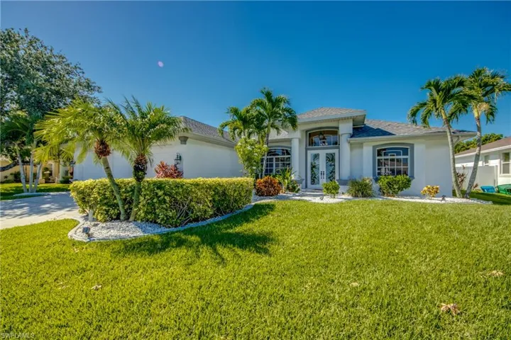 View of front of home with french doors and a front lawn