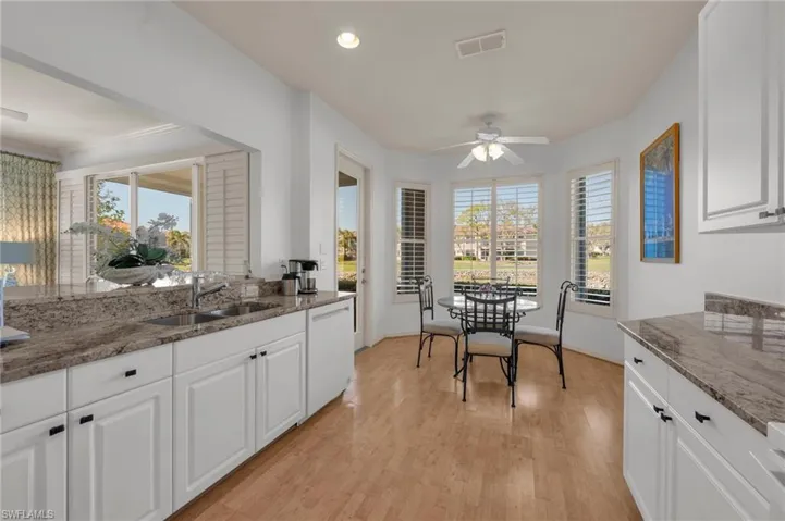 Kitchen featuring white cabinetry, dark stone countertops, ceiling fan, light wood-type flooring, and recessed lighting