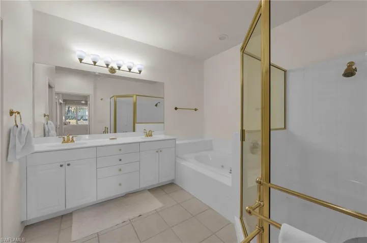 Full bathroom with a shower stall, light tile patterned flooring, double vanity, a bath, and connected bathroom