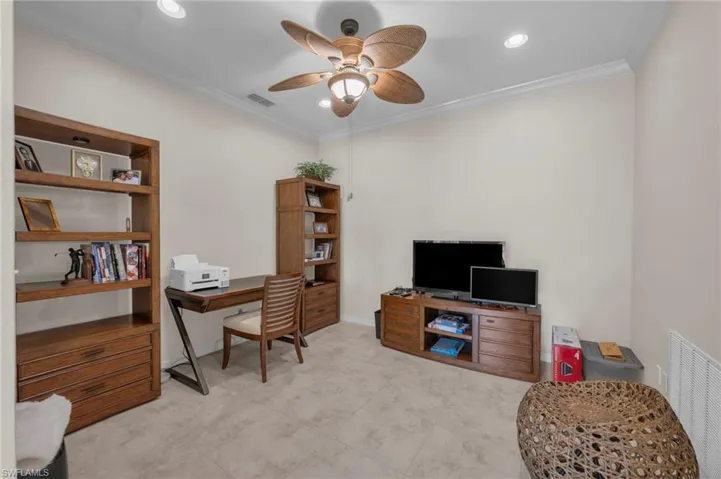 Den with crown molding, a ceiling fan, and recessed lighting