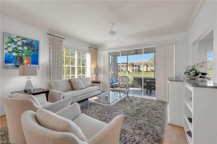 Great Room featuring ornamental molding, a ceiling fan, light laminate floors, and healthy amount of natural light