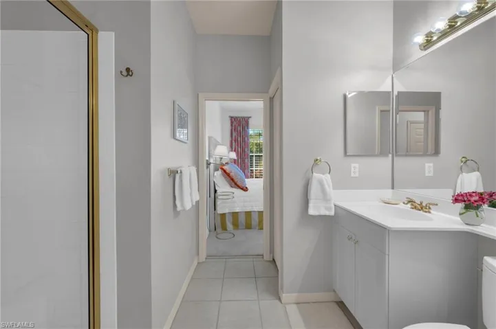 Guest Bathroom with vanity, a tile shower, and light tile patterned floors