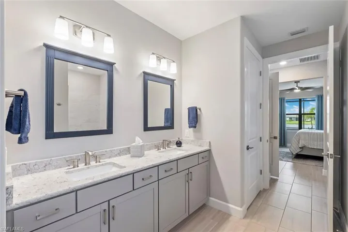 Bathroom with double vanity, ensuite bath, and a ceiling fan