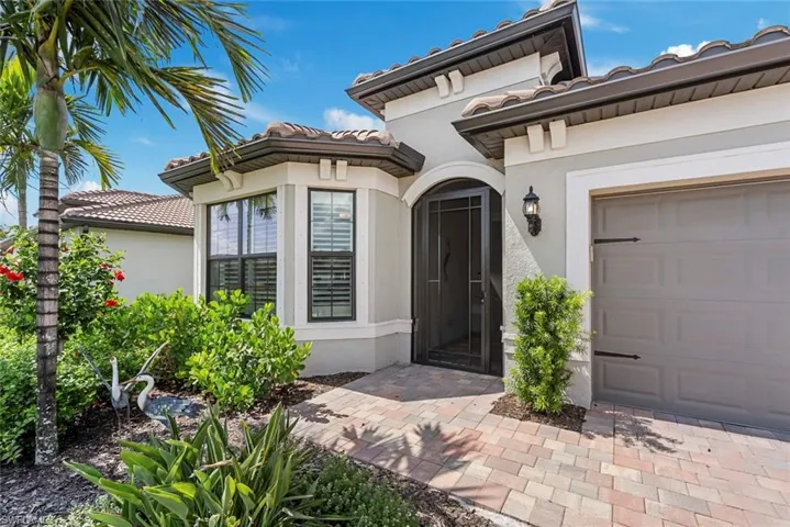 Property entrance featuring a tile roof, stucco siding, and a garage