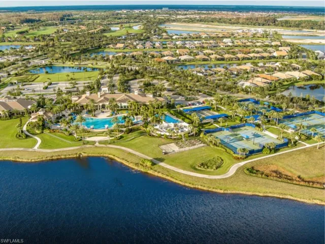 Aerial view of residential area featuring a nearby body of water and a pool