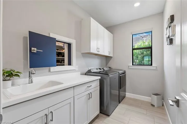 Washroom featuring separate washer and dryer, cabinet space, and recessed lighting