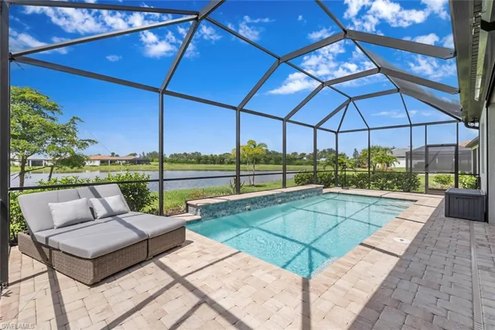 Outdoor pool featuring a patio area, a water view, an outdoor hangout area, and a lanai