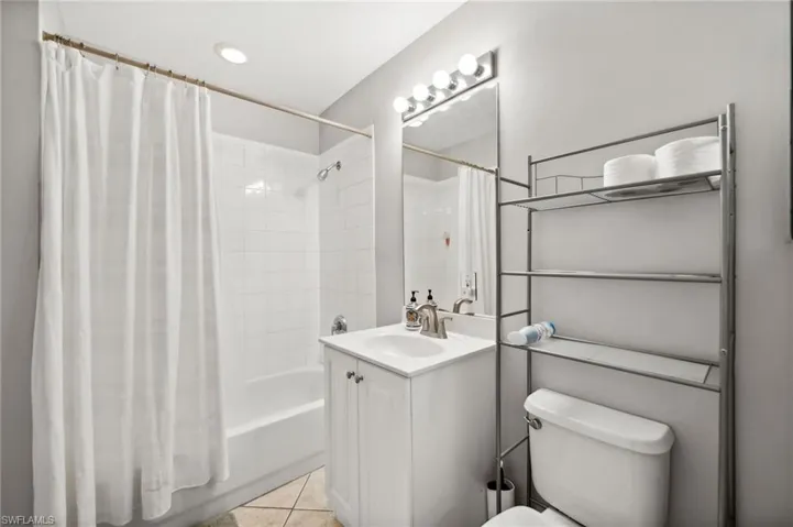 Full bathroom with vanity, toilet, tile patterned floors, and shower / tub combo