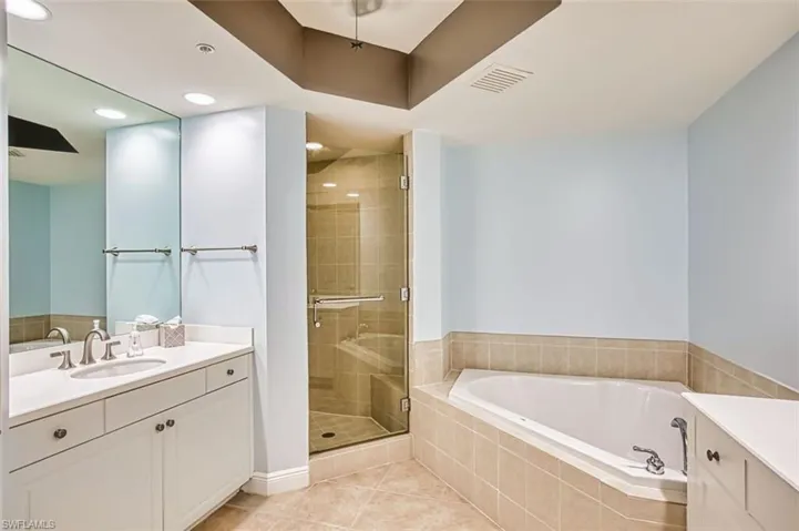 Full bathroom featuring vanity, a shower stall, light tile patterned floors, a garden tub, and recessed lighting
