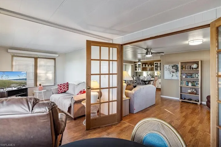 Living area featuring french doors, ceiling fan, and wood finished floors