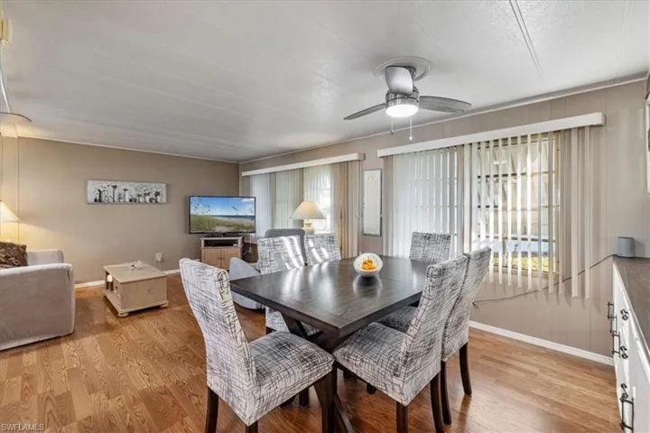 Dining room featuring light wood finished floors, a ceiling fan, and a wealth of natural light