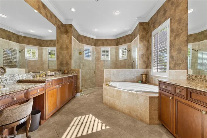 Bathroom featuring a wealth of natural light, walk in shower, and tile walls