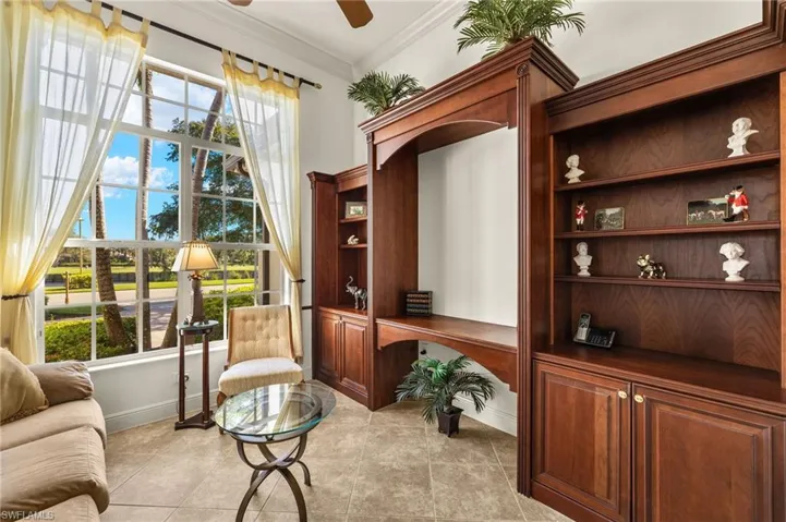Sitting room featuring built in desk, plenty of natural light, a ceiling fan, and crown molding