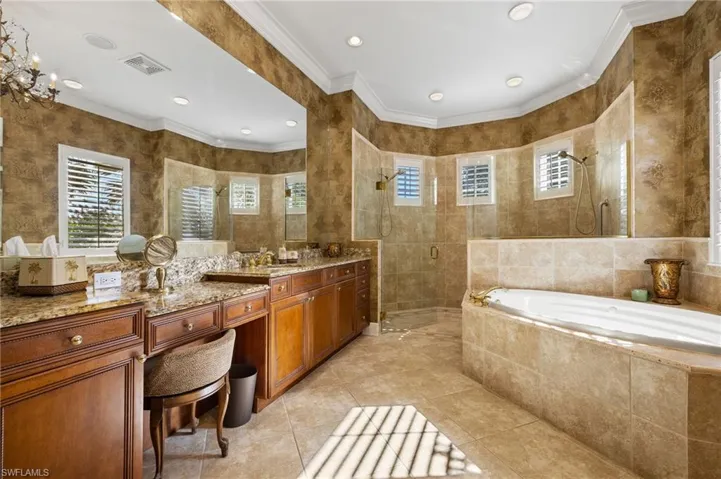 Full bathroom featuring a walk in shower, vanity, visible vents, tile walls, and a bath
